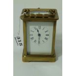 Brass framed carriage clock, with white dial and roman numerals, 4”h, with key.