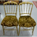 Matching pair of gilt decorated side chairs, with rail backs, out-swept legs.