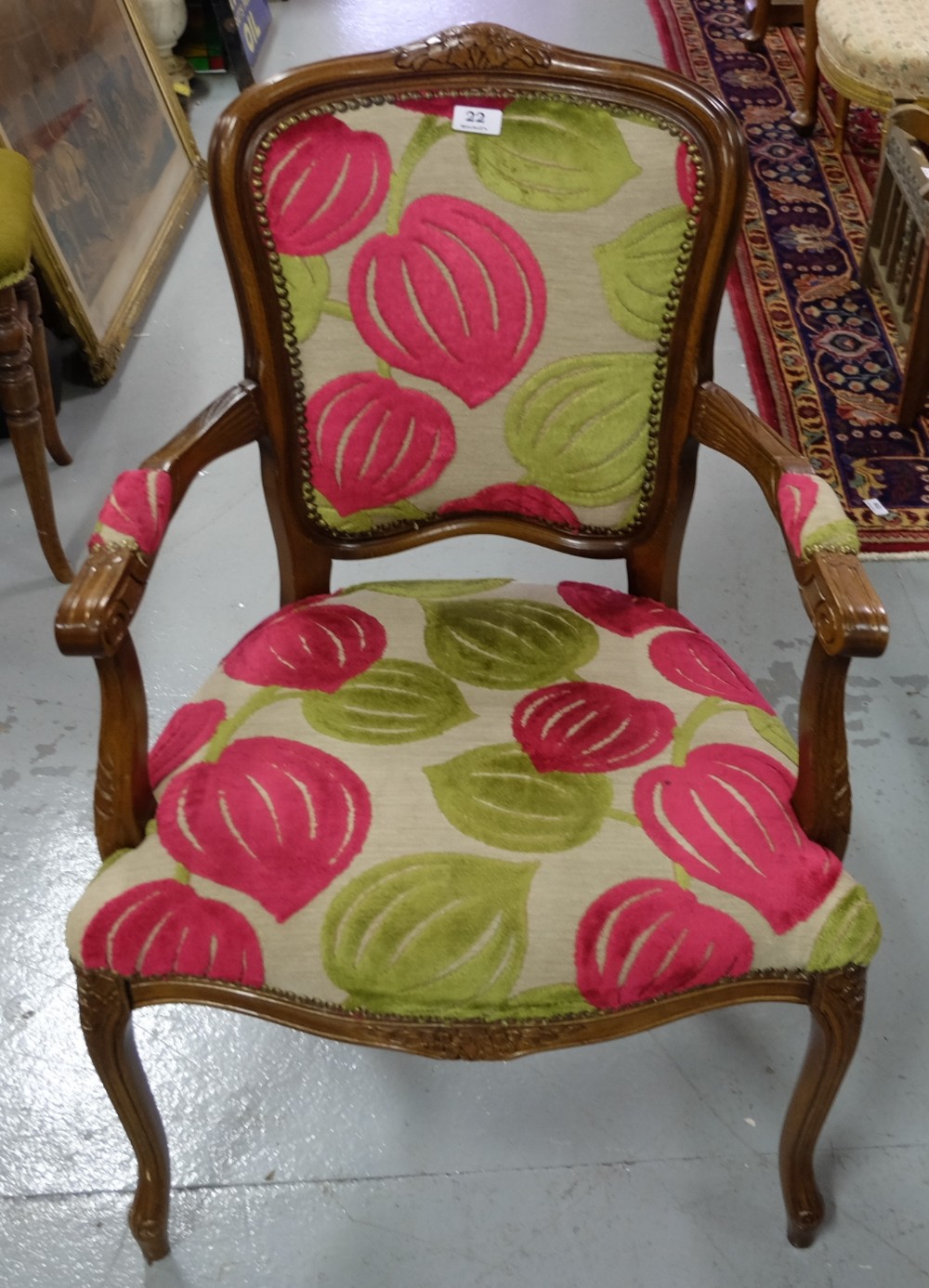 Modern walnut framed Armchair, on sabre legs, red and green floral pattern back and seat.