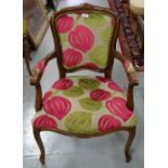 Modern walnut framed Armchair, on sabre legs, red and green floral pattern back and seat.