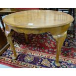 Oval shaped walnut coffee table on pad feet, 30”w.