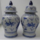 Matching pair of Blue & White Chinese style Bulbous Vases, with lids and cone shaped finials,