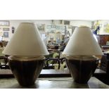 Pair of large bulbous impressed copper table lamps with cream shades, electric.