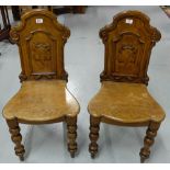 Matching Pair WMIV Oak Hall Chairs, the backs featuring mouldings and crests, on turned front legs.