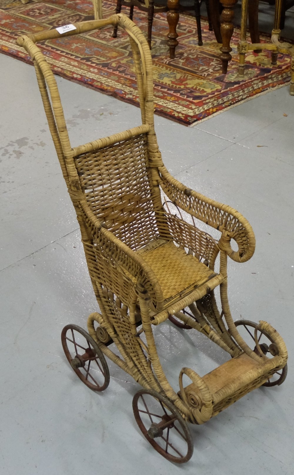 19thC wicker child’s stroller, on metal wheels.