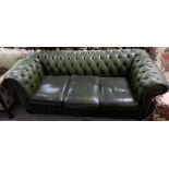 Green leather covered Chesterfield Sofa, with buttoned back, side arms and front panel, 77”w