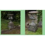 Pair of cast iron urns on stands.