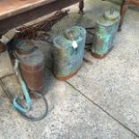 Three copper knapsack sprayers.