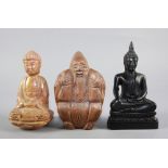 Tre statuette in legno e pietra di cui una raff. ''VECCHIO CON TARTARUGA'' e due raff. ''BUDDHA''.