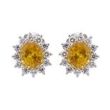 PAIR OF 18K WHITE GOLD EARRINGSeach set with an oval cut yellow sapphire (approx. 3.50ct. each)