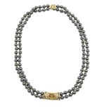 FRENCH HEMATITE BEAD NECKLACEwith 18k yellow gold central panel, clasp and spacers, bezel set with