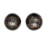 Two 6 pounder cannon balls from the field of Waterloo, with gilt painted inscription: “Taken on