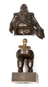 An amusing bronzed miniature figure of a very obese Louis XVIII, in full dress, holding his