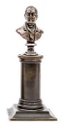 A miniature brass bust of Wellington, on a bronzed column and pedestal base, 5½” overall. Good