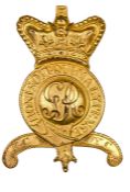 An officer’s gilt badge for Tarleton helmet, GR cypher within crowned Garter and motto, on a