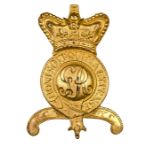 An officer’s gilt badge for Tarleton helmet, GR cypher within crowned Garter and motto, on a