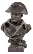 A blackened spelter bust of Napoleon, wearing bicorne hat and cloak, integral square base with