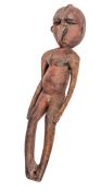 A small New Guinea carved wood figure,  10” overall, the flattened head with ridge running from back