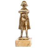A small gilt bronzed figure of Napoleon, standing with arms folded, in overcoat and bicorne hat,
