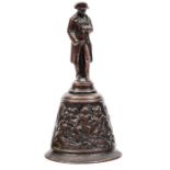 A small bronze handbell, the handle in the form of standing figure of Napoleon wearing bicorne hat