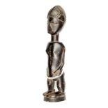 An Ivory Coast Baoule carved hardwood standing female figure, height 13”, with short legs, long