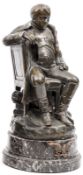 A bronze figure of Napoleon,  seated sideways on a chair, wearing greatcoat without headdress,