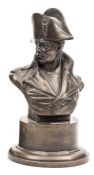 A bronzed head and shoulders bust of Napoleon, facing to the right, wearing bicorne hat and cloak,