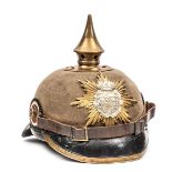 A Saxon pickelhaube, with leather lined khaki felt skull,  patent leather peak and neck guard, bi-