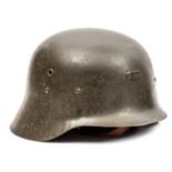 A German M42 type steel helmet, olive green with inserted grommet vents, small brass liner retaining