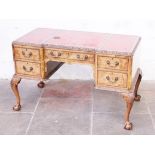 A walnut desk having tooled leather top, cabriole legs with ball and claw feet. Circa1930. W125cm