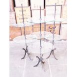 A group of three cast iron display stands with adjustable glass shelves by Sheldon Harris circa