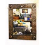 An Arts and Crafts hammered metal framed mirror. 42cm x 53cm