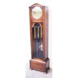 An oak long case clock circa 1920 having Westminster chime movement and brass dial with silvered