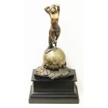 An Art Nouveau bronzed mantel clock formed as a female nude floating above a sphere on a black