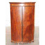 A Georgian mahogany bow front corner cabinet. H113cm