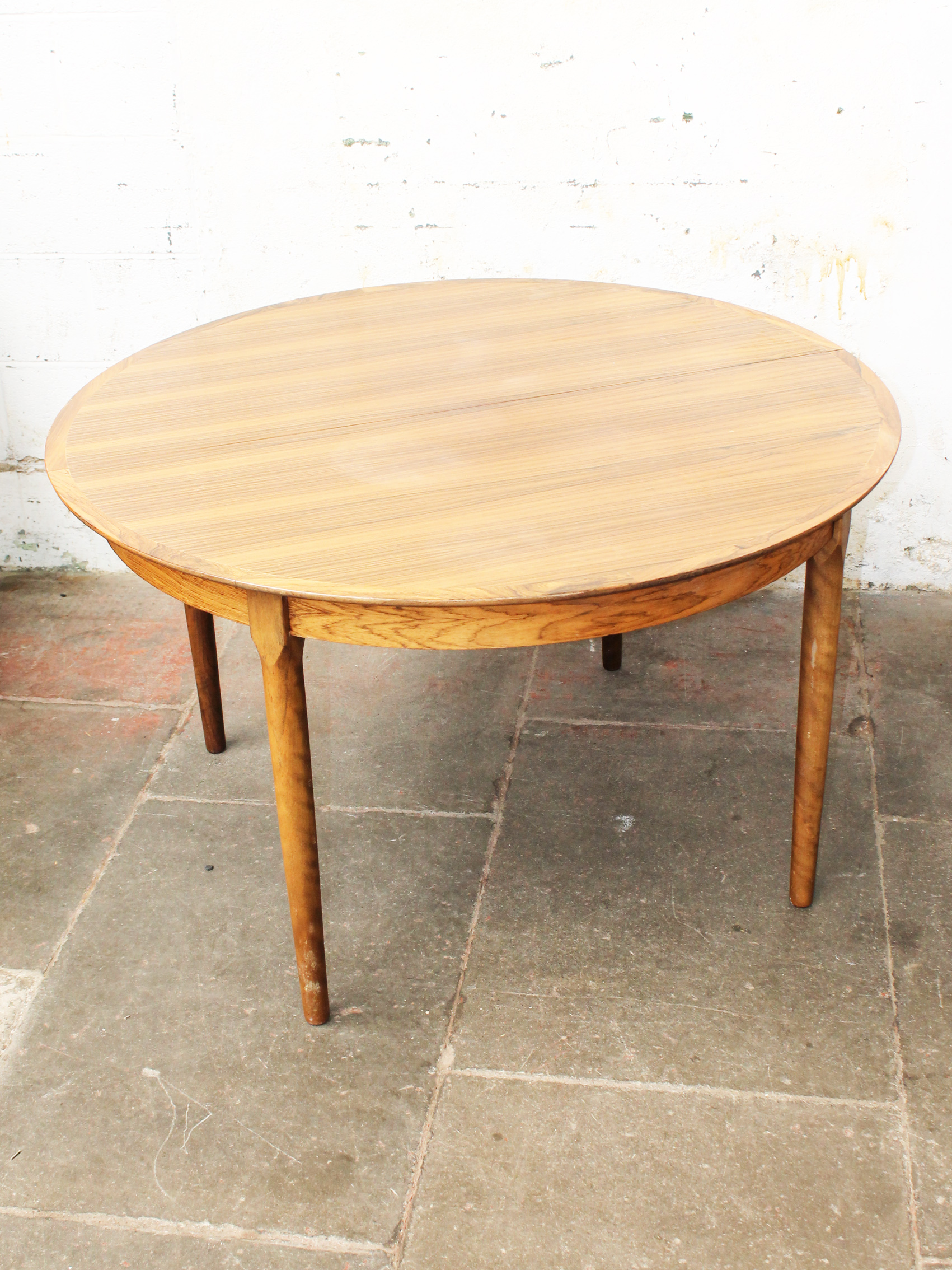 A Danish rosewood extending round dining table with two leaves possibly designed by Niels Moller.