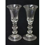 A pair of 18th Century style double knop, air drop drinking glasses with bell bowl, domed and folded