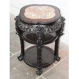 A Chinese carved hardwood and marble three tier table. H81cm. Diam. 63cm