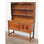 An Arts and Crafts style oak dresser. W137cm D52cm H183cm