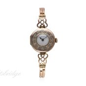 A LADIES 9CT SOLID GOLD ROLEX HALF HUNTER BRACELET WATCH CIRCA 1920s
D: White enamel dial. M: 15