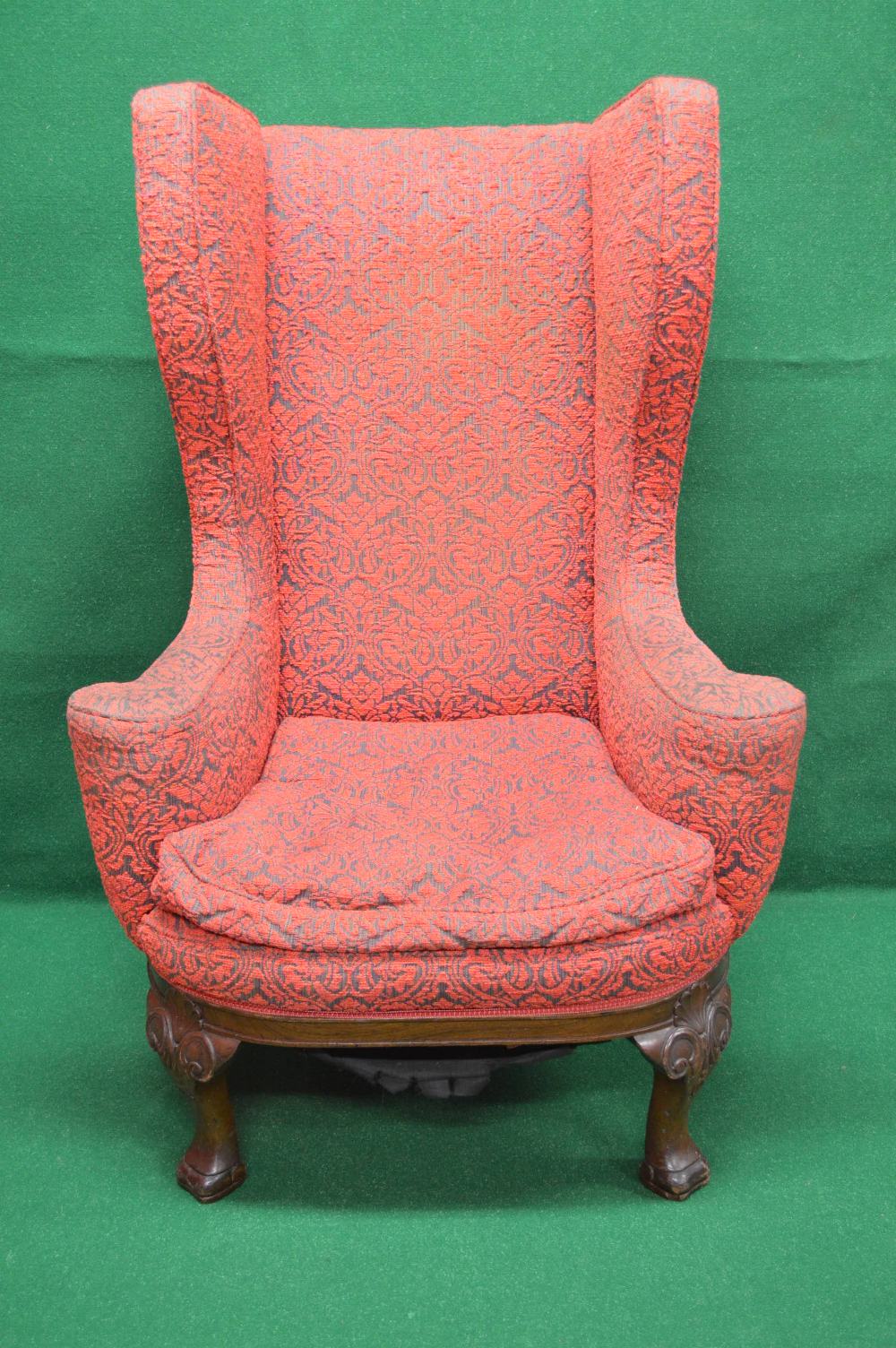 A high backed wing armchair having outwa