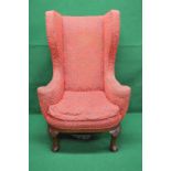 A high backed wing armchair having outwa