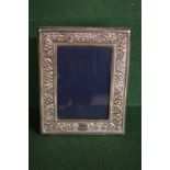 A silver photograph frame having floral