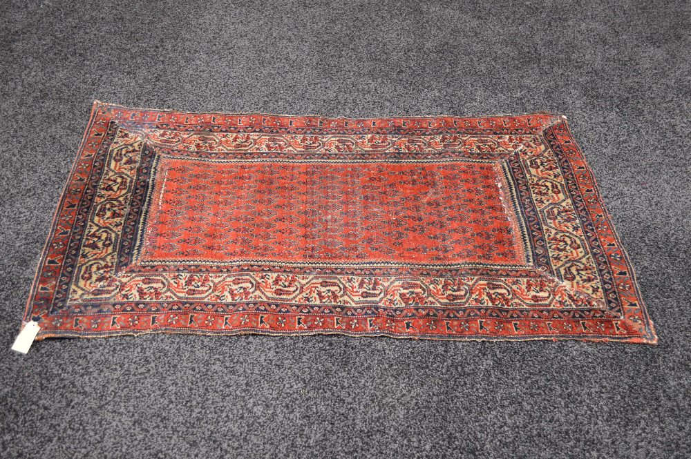 A red ground rug with blue and white pat