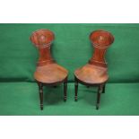 Pair of shaped solid back mahogany hall chairs with bird crests and solid seats,