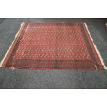 Red ground rug with black and cream pattern with end tassels - 98" x 110"