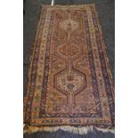 Rust ground rug with red, blue and cream pattern - 96" x 41.