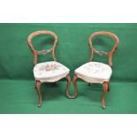 Pair of walnut framed balloon back dining chairs with carved back rails over tapestry seats,