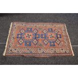 Red ground rug having blue, cream and black pattern with end tassels - 56" x 37"