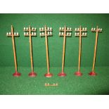 Group of six painted metal telegraph poles with conductors, standing on circular metal bases,